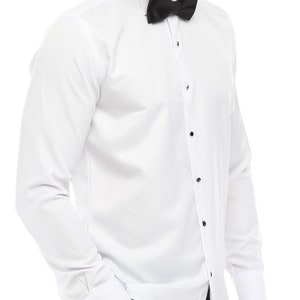 May include: A white long-sleeve dress shirt with a black bow tie and a black collar trim. The shirt has a button-up front and french cuffs.