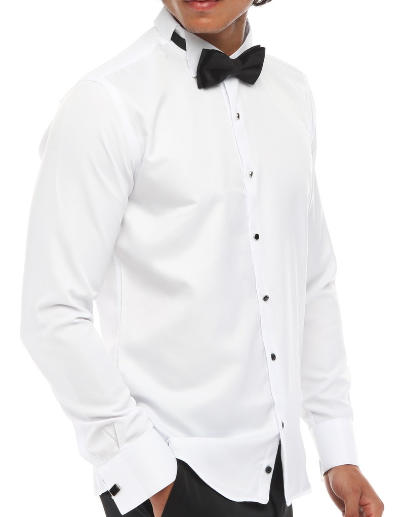 May include: A white long-sleeve dress shirt with a black bow tie and a black collar trim. The shirt has a button-up front and french cuffs.