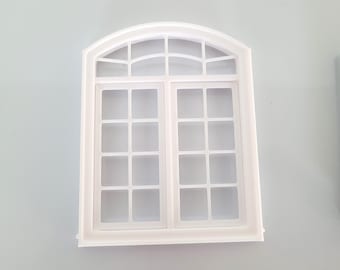 May include: A white, arched window with a grid pattern. The window has a rectangular shape with a curved top and is divided into multiple panes. The window is made of a solid white material and is likely a decorative item or a miniature model.