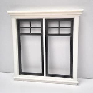 May include: A miniature white window frame with two panes, each divided into four sections by black mullions. The window has a decorative top and bottom trim, creating a classic architectural detail. Ideal for dollhouses or craft projects.