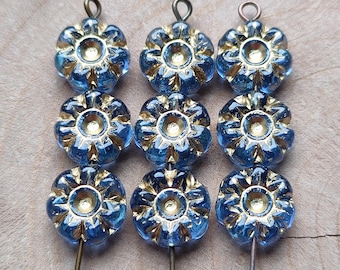 Puede incluir: Nueve cuentas azules y doradas con forma de flor. Cada cuenta tiene un diseño central dorado rodeado de pétalos azules. Las cuentas tienen un lazo en la parte superior y un alfiler metálico que se extiende desde la parte inferior.
