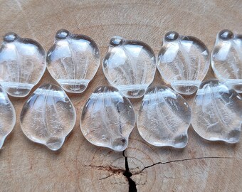 May include: Ten clear glass beads with a textured, frosted finish. The beads are oval shaped and have a slight curve to them.