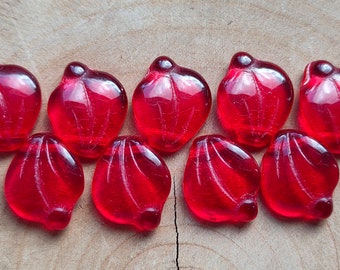 May include: Ten red glass beads in the shape of a flower petal. The beads are translucent and have a slight shimmer.