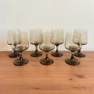 Vintage set of 7 Smokey grey drinking glasses with stems - 5.5” t x 2.6” w - retro barware drink ware - wine glasses