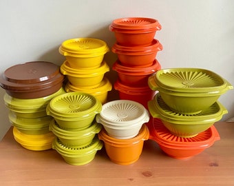Pode incluir: Um conjunto de 12 tigelas de nidificação vintage em vários tons de amarelo, laranja e marrom. As tigelas são feitas de plástico e têm uma forma lisa e arredondada.