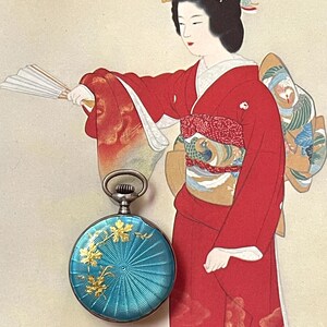 May include: A round pocket watch with a vibrant turquoise guilloch&eacute; enamel finish, featuring a delicate gold-toned floral overlay. The watch has a silver-colored metal casing and a circular winding crown at the top, showcasing intricate radial patterns.