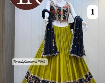 Peut inclure: Un ensemble lehenga choli sans manches composé d'un corsage bleu marine foncé à broderies florales multicolores et d'une dupatta assortie. La jupe est vert olive uni avec une large bordure bleu marine à motifs floraux brodés à l'ourlet.