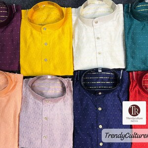 May include: A collection of eight folded, button-down shirts in various colors, including purple, yellow, peach, lavender, navy, and red. Each shirt has a mandarin collar and a textured pattern. The image includes the text "TrendyCultureINDYA".