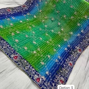 Op de afbeelding: Een levendige, ombre-geverfde sjaal in blauwe en groene tinten, met ingewikkelde zilveren borduursels en kleine, sprankelende versieringen. De sjaal heeft een gedetailleerde rand met rode accenten en de tekst "Option 3".