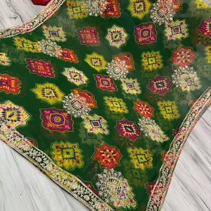 May include: A green sheer fabric featuring a repeating pattern of colourful geometric shapes and detailed embroidery. The border is decorated with gold-coloured embellishments. The text "Option 2" is visible in the bottom right corner.