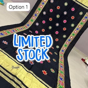 May include: Black textile with colorful embroidered floral patterns and gold trim. The textile has the words "LIMITED STOCK" in a blue font. The textile is from Trendyculture Indya.