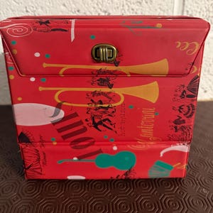 Estojo vintage para discos de vinil de 7 polegadas dos anos 1960. Apresenta um design com tema de jazz. Comporta 25 singles de vinil.