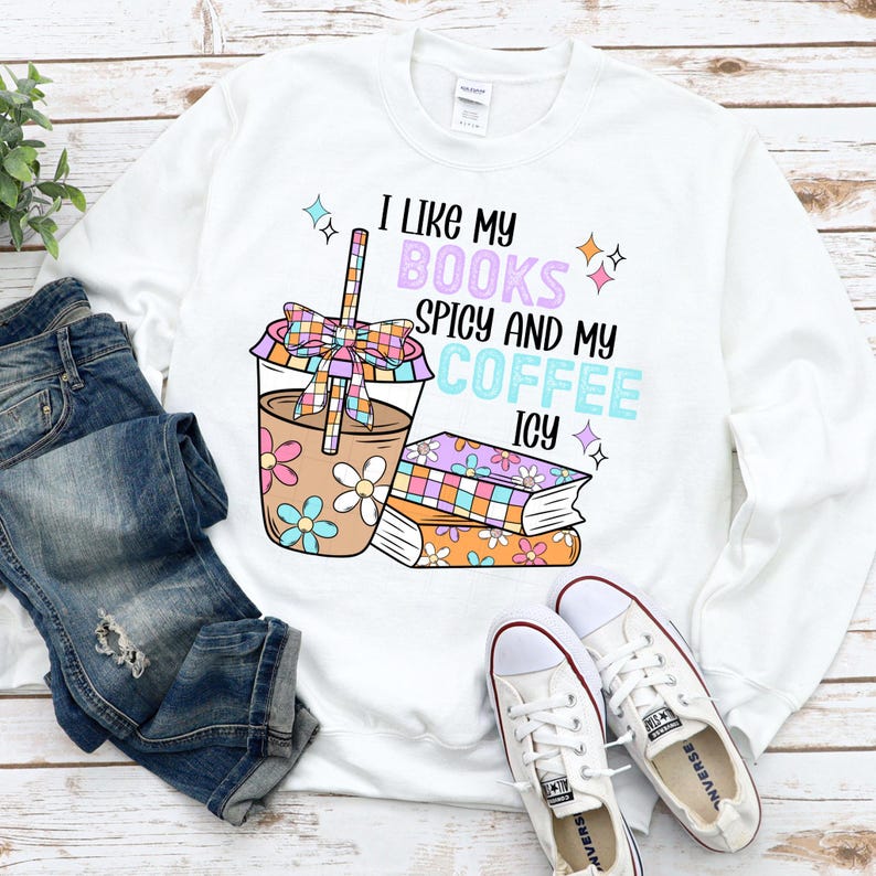May include: White long-sleeve sweatshirt with the text "I like my books spicy and my coffee icy" and a cartoon illustration of a coffee cup and stacked books.