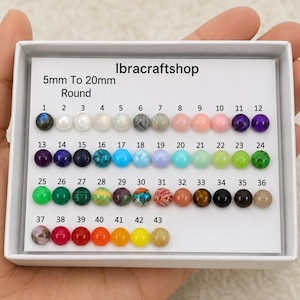Puede incluir: Una variedad de 43 cuentas redondas en una caja blanca, que van de 5 mm a 20 mm. Las cuentas son de varios colores, incluyendo rosa, verde, azul y marrón. El texto "Ibracraftshop" y "5mm To 20mm Round" son visibles.