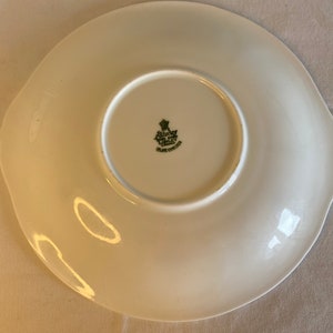 May include: White ceramic plate with a green and gold logo that reads "Royal Crown China Made in England".