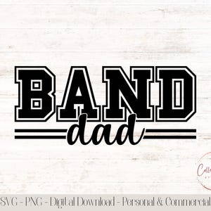 May include: Black and white graphic design with the words "BAND dad" in a collegiate font. The word "BAND" is in a bold, block letter style, and "dad" is in a cursive font. The design includes two horizontal lines below the word "dad".