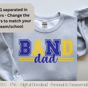 May include: A gray sweatshirt with the words "BAND dad" in blue and yellow lettering. The text "SVG separated in layers - Change the colors to match your team/school" is in a light beige box. The bottom of the image reads "SVG - PNG - Digital Download - Personal & Commercial".