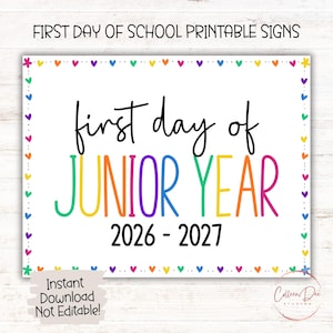 May include: A rectangular printable sign with a white background and a border of colourful hearts and flowers. The text reads FIRST DAY OF SCHOOL PRINTABLE SIGNS, first day of JUNIOR YEAR, and 2026 - 2027. The words are in black and rainbow-coloured lettering.