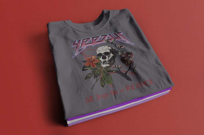 May include: Gray t-shirt with a skull and floral design. The text "YEEZY" is printed in a metallic font above the skull. The text "All Things Go to Heaven" is printed below the skull.