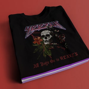 May include: Black t-shirt with a skull and floral design. The text "YEEZY" is printed in a large, bold font above the skull. The text "All Dogs Go to HEAVEN" is printed below the skull.