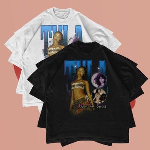 May include: Two t-shirts with a retro design featuring a woman with the text "TILA Make You Sweat". The t-shirts are one white and one black.
