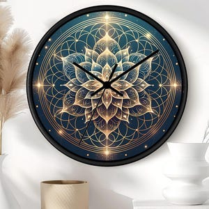 Puede incluir: Un reloj de pared redondo con marco negro que presenta un fondo azul oscuro y un diseño geométrico de flor de loto en color dorado. La esfera muestra líneas simétricas intrincadas y puntos brillantes en forma de estrella con manecillas negras.