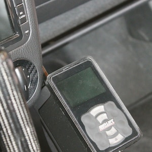 May include: A black air suspension control unit with a digital display and a control panel labeled "Air Lift Performance".