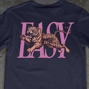 May include: Navy blue t-shirt with a pink tiger graphic and the text "EASY LADY". The shirt is made with a direct-to-garment printing method. The text "NAVY" is at the bottom of the shirt.