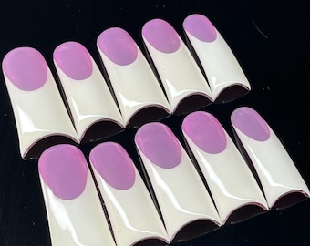 May include: A set of ten false nails, each featuring a white base and a lavender oval tip. The nails are arranged in two rows, presenting a French manicure design.