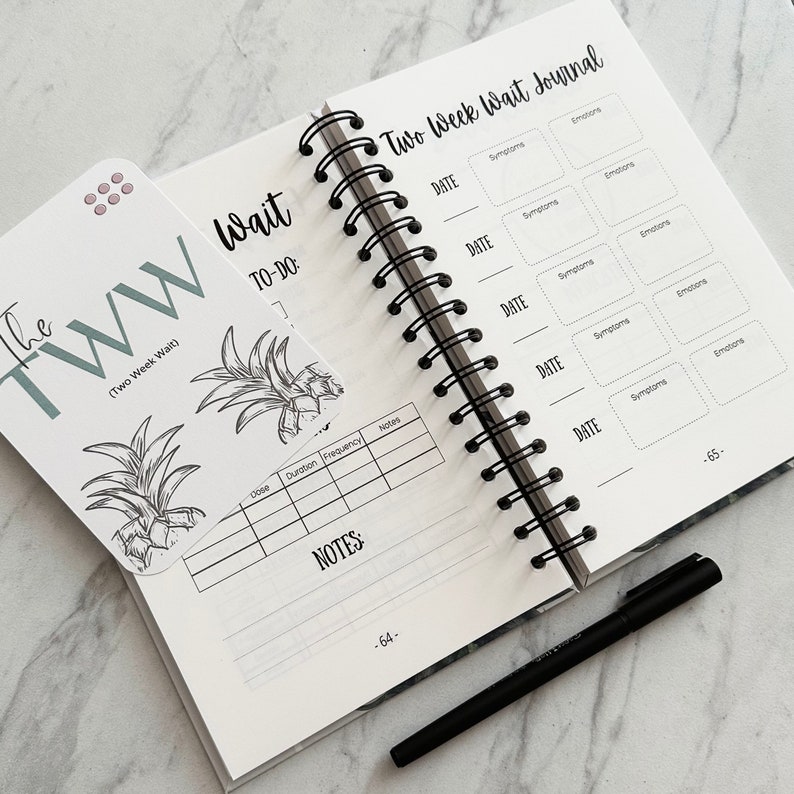 Puede incluir: Un diario de espera de dos semanas con un dise&ntilde;o de pi&ntilde;a en blanco y negro en la portada. El diario tiene una encuadernaci&oacute;n en espiral e incluye secciones para registrar fechas, s&iacute;ntomas, emociones y notas. El texto "The TWW (Two Week Wait)" est&aacute; impreso en una tarjeta separada.