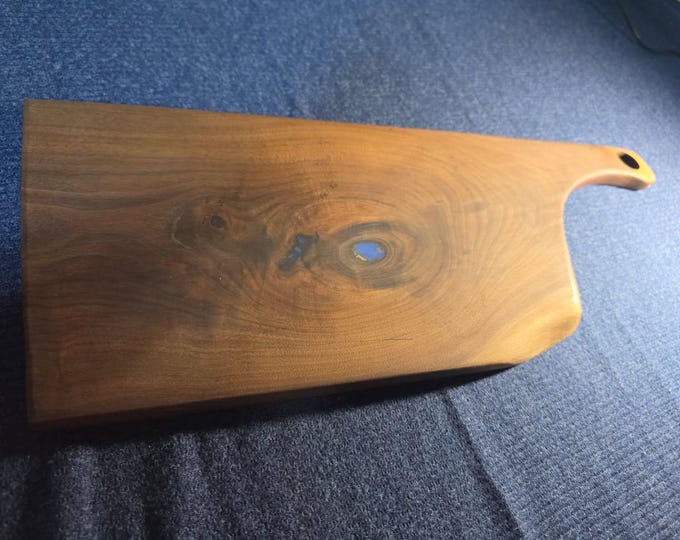 Custom Black walnut cutting/cheese board with a natural hole filled with blue epoxy