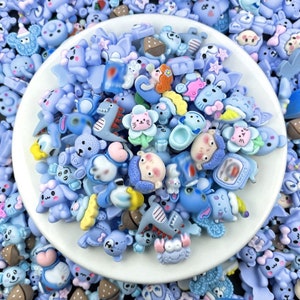 Può includere: Una collezione di ciondoli in resina blu e bianca con vari personaggi di animali e cartoni animati. I ciondoli sono perfetti per aggiungere un tocco fantasioso a gioielli, artigianato e altri progetti.