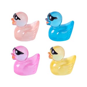 May include: Four rubber duck toys with sunglasses. The ducks are pink, blue, yellow, and light pink. Each duck has a different color of sunglasses.