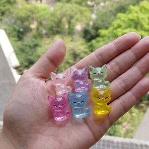 Puede incluir: Seis pequeñas figuras de zorro translúcidas en varios colores, incluyendo rosa, morado, verde claro, azul y amarillo. Cada zorro tiene un acabado suave y pulido con rasgos faciales tallados, orejas puntiagudas y una cola enroscada.