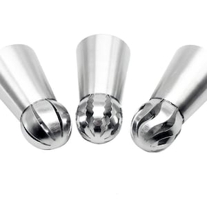 May include: Three silver metal piping tips with a ball-shaped end and a ridged design. The tips are used for decorating cakes and pastries.