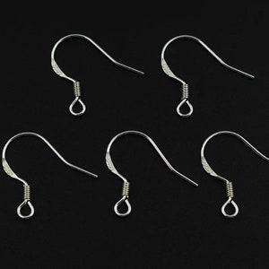 May include: Five silver earring hooks with a spring closure. The hooks are made of metal and are designed for attaching earrings.