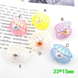 May include: Five different colored plastic seashells with pearl accents. The shells are approximately 23 mm by 15 mm. The shells are yellow, pink, purple, clear with a rainbow iridescent finish, and blue with a rainbow iridescent finish.