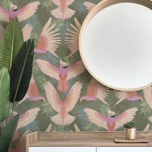 May include: A room with a green parrot wallpaper, a round mirror, and a white cabinet. The wallpaper features a repeating pattern of pink and peach parrots with outstretched wings amidst green foliage. A small succulent sits on the cabinet.