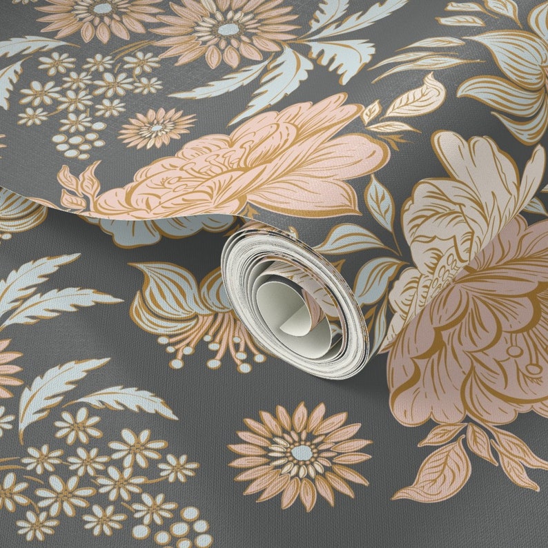 May include: A roll of wallpaper featuring a dark gray background with a repeating floral pattern. The design includes large, stylized flowers in shades of soft pink and muted gold, accented by light blue leaves and small white flower clusters.