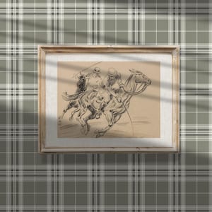 May include: A black and white drawing of two people riding a horse. The drawing is framed in a light wood frame and is hanging on a wall with a green and white plaid pattern.