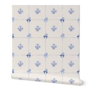 May include: Wallpaper featuring a grid pattern of thin blue lines intersecting at small blue bows. The squares contain small blue floral sprigs on a light cream background. The design is repetitive and symmetrical across the entire surface.