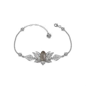 May include: A silver bracelet with a filigree design featuring a gray stone in the center. The bracelet is shaped like a lotus flower.