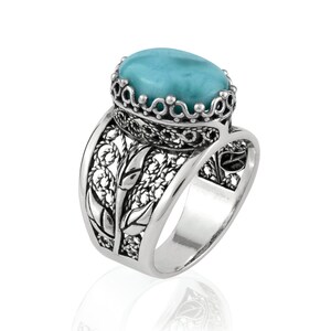 May include: A silver ring with a turquoise gemstone set in a filigree design.