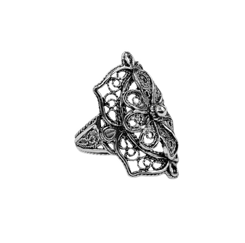 May include: A silver filigree ring with a floral design. The ring is intricate and delicate, with a raised center piece.