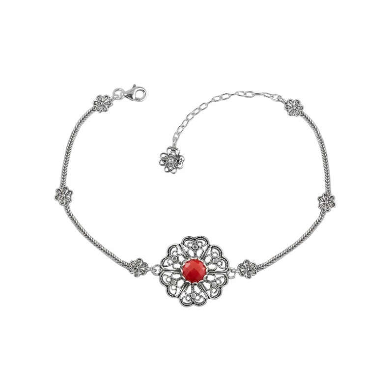 May include: A silver bracelet with a red gemstone in a filigree flower design. The bracelet has a delicate chain and small flower accents.