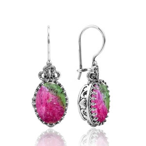 May include: Silver earrings with a pink and green oval gemstone set in a filigree design.