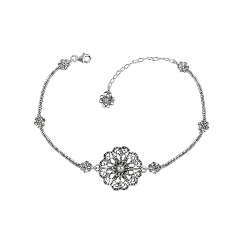 May include: A silver bracelet with a delicate floral design. The bracelet features a large, ornate flower charm in the center and smaller flower charms on the sides. The bracelet is made of a thin chain and has a lobster clasp.