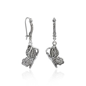 May include: Silver filigree butterfly dangle earrings. The earrings feature a delicate butterfly design with intricate details.