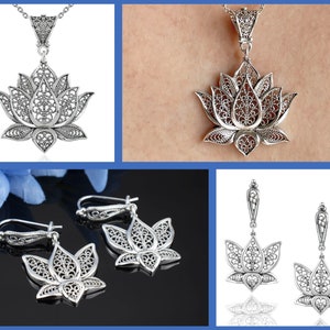 May include: A set of silver filigree lotus flower jewelry, including a pendant necklace and a pair of earrings.