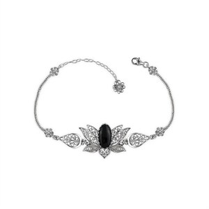 May include: A silver bracelet with a black gemstone set in a filigree lotus flower design.